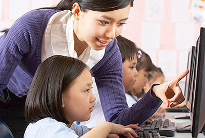 Teacher helping children learn English online